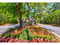 Entrance to community with manicured landscaping, trees, and arched brick entry feature at 6972 Pumpkinseed Dr, Johns Island, SC 29455