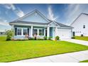Charming single-story home featuring a well-manicured lawn, covered porch, and attached garage at 6972 Pumpkinseed Dr, Johns Island, SC 29455