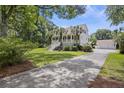 Beautiful home with a long driveway, attached garage, and a well-maintained lawn with mature trees at 7879 Gull Bay Dr, Awendaw, SC 29429