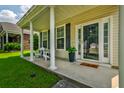 Charming front porch with columns, seating, and a welcoming entrance at 8938 Planters Row Ln, Summerville, SC 29485