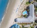 Aerial view of a condo building steps from the beach, featuring a pool and ample parking at 9002 Palmetto Dr # 420, Isle of Palms, SC 29451