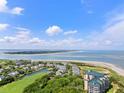 Scenic aerial view showcasing the beautiful community with ocean views, golf course, and condo building at 9002 Palmetto Dr # 420, Isle of Palms, SC 29451