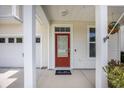 Red front door is framed by white columns and a small porch with tasteful decor at 106 Sago Ct, Summerville, SC 29486
