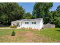Wide view showcasing white brick exterior, well-manicured lawn and mature trees at 1107 S Shadow Dr, Mount Pleasant, SC 29464