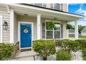 Inviting front porch with a blue door, decorative wreath, and charming seating, creating a welcoming entrance at 1301 Wild Goose Trl, Summerville, SC 29483