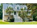 Beautiful home with a metal roof, lush landscaping, and a spacious covered porch, ideal for relaxing at 142 Maxwell Rd, Summerville, SC 29483