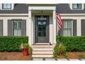 Inviting front door with dark trim, decorative windows, and a charming brick paver landing at 1446 Burningtree Rd, Charleston, SC 29412