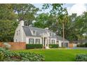 Charming home boasts mature trees, a manicured lawn, dark shutters, and an attached two-car garage at 1446 Burningtree Rd, Charleston, SC 29412