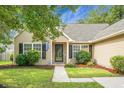 Inviting front of house with a landscaped yard and a concrete walkway leading to a front door at 213 Avonshire Dr, Summerville, SC 29483