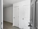 Entryway with a dark front door, two white interior doors, and wood floors at 2174 Eleanor Dr, North Charleston, SC 29406
