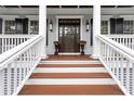 Inviting entryway with a stained wood door, sidelights, decorative columns and potted flowers at 2293 Beckenham Dr, Mount Pleasant, SC 29466