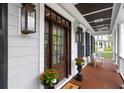 Charming front porch with wood flooring, comfortable seating, stylish lighting, and classic white columns at 2293 Beckenham Dr, Mount Pleasant, SC 29466