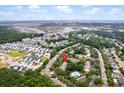 Aerial view of residential neighborhood featuring community pool, lush trees, and blue skies at 241 Kelsey Blvd, Wando, SC 29492