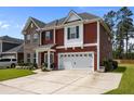 Attractive two-story house featuring brick, red siding, and a two-car garage on a sunny day at 255 Saxony Loop, Summerville, SC 29486