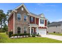 Charming two-story home with brick and red siding, a well-maintained lawn and landscaping at 255 Saxony Loop, Summerville, SC 29486