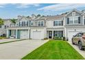 Inviting townhomes with colorful siding, attached garages, and well-maintained lawns on a sunny day at 2582 Kingsfield St, Mount Pleasant, SC 29466