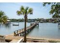 Picturesque waterfront property with private dock, boat lift, and stunning views of the serene water and neighboring homes at 2619 Buccaneer Rd, Isle of Palms, SC 29451