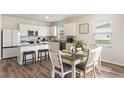 Bright dining area features hardwood flooring, a decorative table setting, and lots of natural light at 286 W Bradford Pointe Dr, Summerville, SC 29486