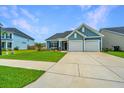 Charming home showcasing a two-car garage, manicured lawn, and blue siding at 302 Fiddleback Dr, Summerville, SC 29486