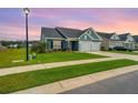 Beautiful home with manicured lawn and two-car garage is seen at sunset at 302 Fiddleback Dr, Summerville, SC 29486