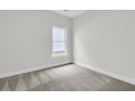 A clean, carpeted bedroom with neutral walls and a window allowing natural light at 3218 Pinewood Dr, Ladson, SC 29456