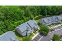 Aerial view of townhouses with a gray roof near parking, and a small pond, surrounded by greenery at 333 Flyway Rd, Goose Creek, SC 29445