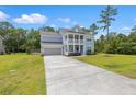 Two-story home featuring a double porch, well-maintained lawn, and long driveway at 4007 Oxeye, Johns Island, SC 29455
