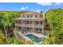 Expansive three-story home featuring a private pool and deck area with multiple seating and dining options at 43 Surfsong Rd, Kiawah Island, SC 29455