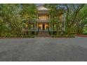 Stately three-story home with a classic design, featuring a grand entrance and surrounded by mature trees at 43 Surfsong Rd, Kiawah Island, SC 29455