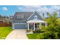 Charming home featuring a covered porch, gray siding, a well-manicured lawn, and an attached two-car garage at 627 Macintyre Cir, Summerville, SC 29486