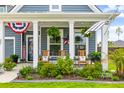 Relaxing front porch with rocking chairs, lush plants and patriotic decor to welcome you home at 627 Macintyre Cir, Summerville, SC 29486