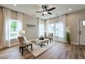 Sunlit living room showcasing hardwood floors, neutral walls, and abundant natural light through draped windows at St, Saint George, SC 29477