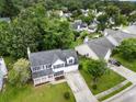 Aerial view of a home featuring a well-manicured lawn and a two-car garage, surrounded by lush greenery at 103 Retriever Ln, Goose Creek, SC 29445