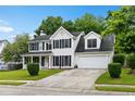 Traditional two-story home with black shutters, a well-kept lawn, and an attached two-car garage at 103 Retriever Ln, Goose Creek, SC 29445