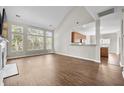 Open-concept living room featuring hardwood floors, tall windows, and a seamless connection to the kitchen for modern living at 106 Brandy Ct, Summerville, SC 29485