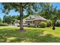Traditional brick home with a well-manicured lawn and a detached two-car garage, surrounded by trees at 1119 Bruton Blvd, Moncks Corner, SC 29461