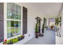Inviting front porch featuring decorative plants, stylish seating, and exterior shutters at 119 White Picket Ln, Summerville, SC 29483