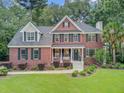 Traditional brick home with a manicured lawn, mature trees, and classic architectural details at 1200 Out Of Bounds Dr, Summerville, SC 29485