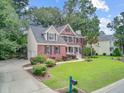 Well-maintained brick residence with a lush green lawn, driveway, and inviting curb appeal at 1200 Out Of Bounds Dr, Summerville, SC 29485