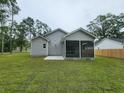 Backyard showing a new home with a screened in back porch, landscaping and green grass at 1207 Albert Storm Ave, Moncks Corner, SC 29461