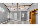 Bright living space featuring wood beams, plank flooring, neutral walls, and attached bath at 127 Roberts Rd, Summerville, SC 29483