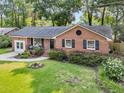 Aerial view of a traditional brick home showcasing a well-manicured lawn and mature trees at 1391 Fairfield Ave, Charleston, SC 29407