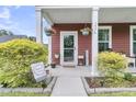 Inviting front entrance with a decorative wreath, hanging plants, and well-manicured landscaping at 1576 Nautical Chart Dr, Charleston, SC 29414