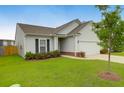 Attractive home with a manicured lawn, a young tree, and a driveway leading to an attached garage at 158 Hayworth Rd, Summerville, SC 29486