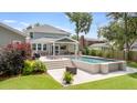 Backyard with a sparkling pool, patio area, lush landscaping, and outdoor kitchen at 1607 Waterside Blvd, Moncks Corner, SC 29461