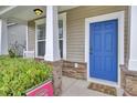 Inviting entryway with a vibrant blue front door, stone accents, and a covered porch at 1634 Eider Down Dr, Summerville, SC 29483
