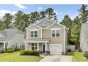 Charming two-story home with a manicured lawn, a blue front door, and attached one car garage at 1634 Eider Down Dr, Summerville, SC 29483