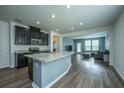 Open concept kitchen with a large island, stainless steel appliances, and dark cabinets at 1689 Eider Down Dr, Summerville, SC 29483