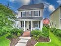 Charming two-story home featuring a cozy front porch, manicured lawn, and a welcoming landscaped yard at 205 White Gables Dr, Summerville, SC 29483