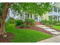 Beautifully landscaped front yard with lush green grass and mature trees, offering a serene setting at 205 White Gables Dr, Summerville, SC 29483